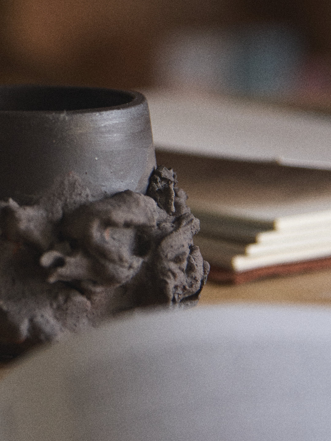 Black ceramic cup with textured design on a blurred background