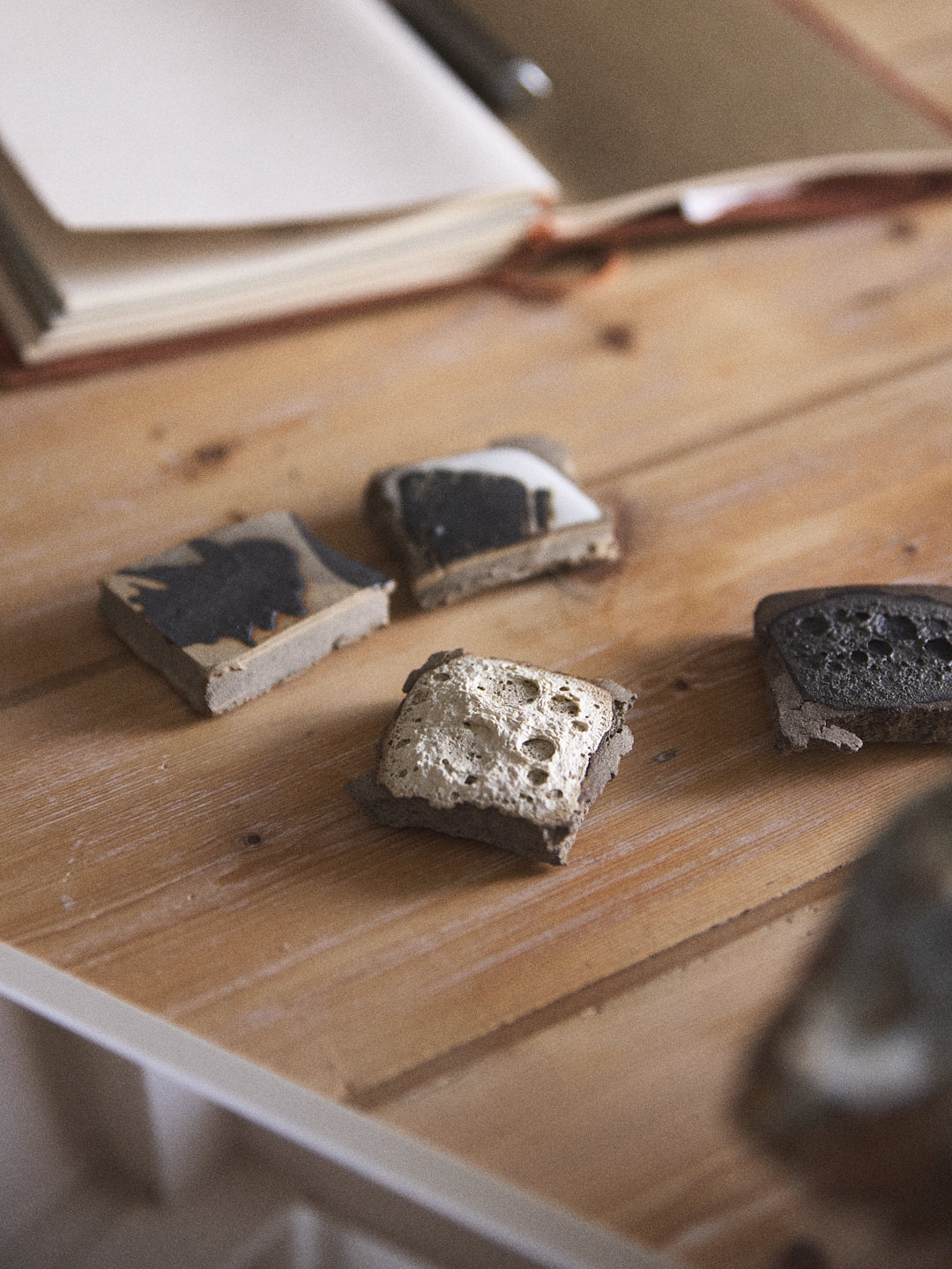 Three small stone-like objects on a wooden surface with a blurred background