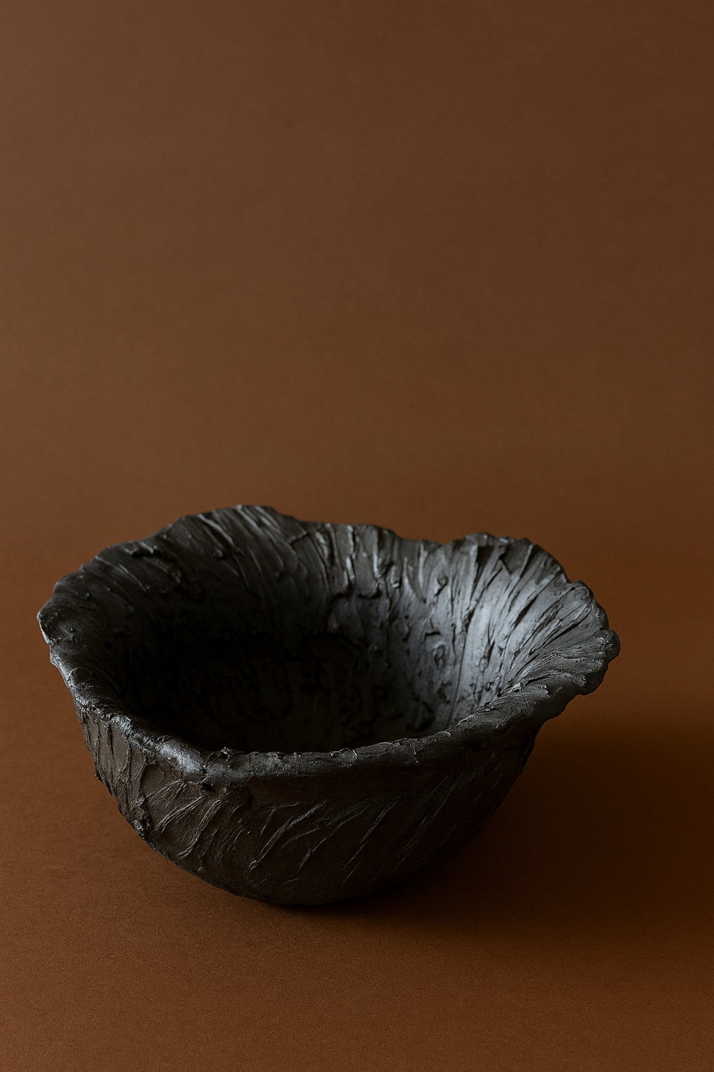 Black textured bowl on a brown background